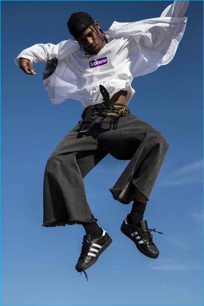 Rapper Travis Scott wears a Prada shirt and Supreme t-shirt with Raf Simons denim shorts, and Adidas sneakers for Paper magazine.