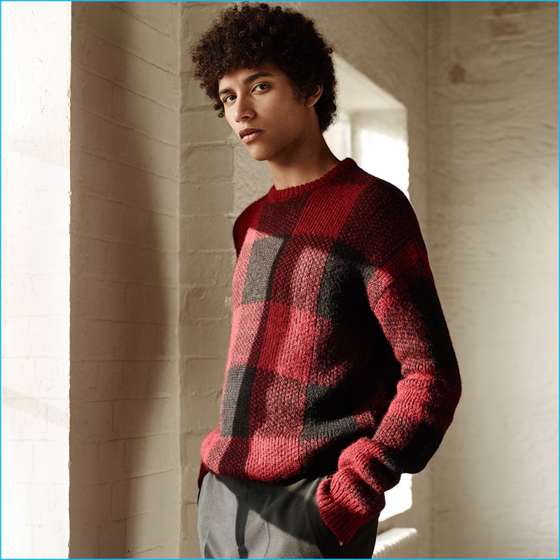 Jackson Hale shines in a black and red buffalo check sweater with grey trousers from Zara Man.