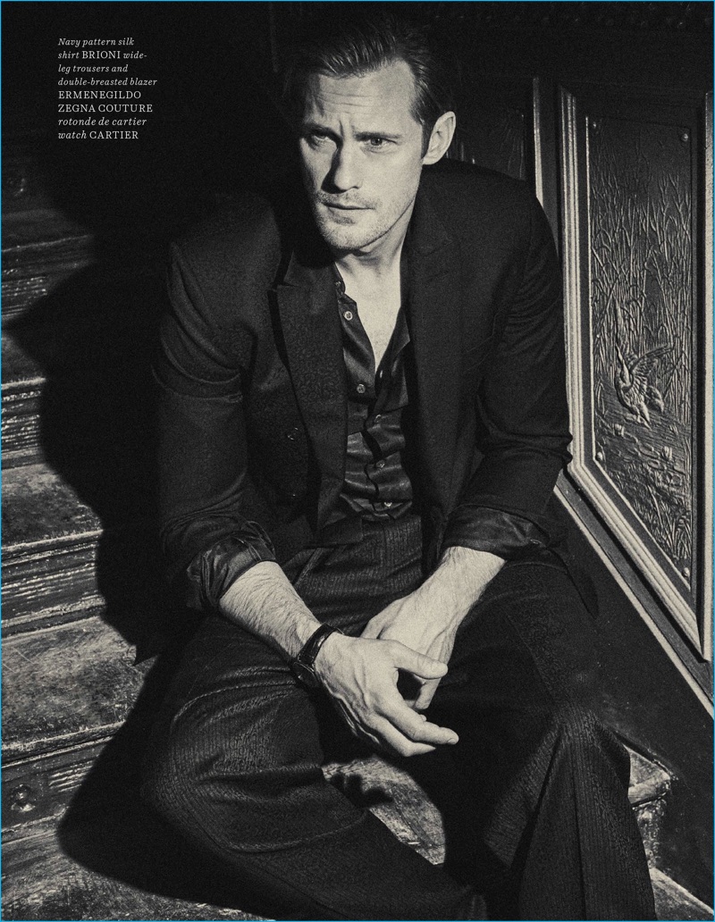 Actor Alexander Skarsgård dons a silk Brioni shirt with a Cartier watch. Skarsgård also wears wide-leg trousers and a double-breasted blazer by Ermenegildo Zegna Couture.