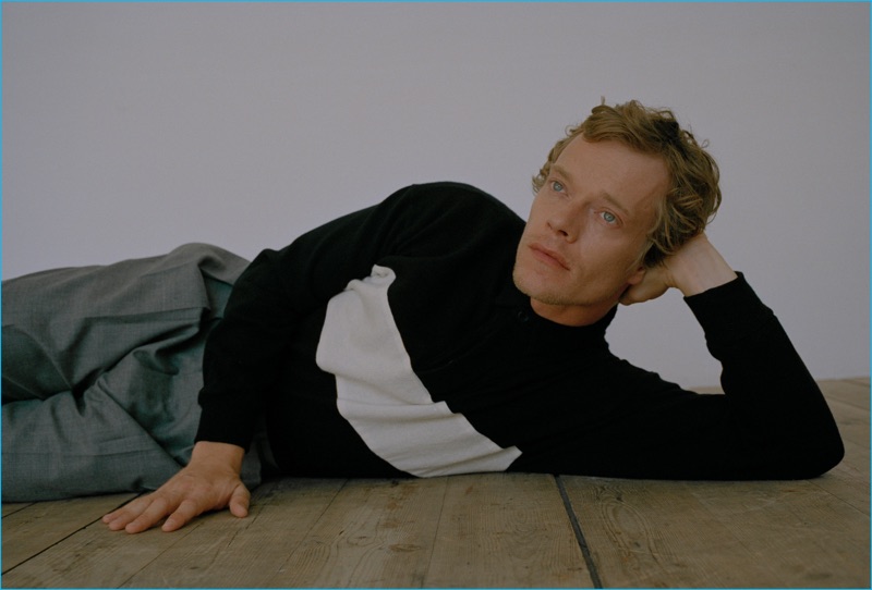 Posing for The Laterals, Alfie Allen dons Officine Generale trousers with a black and white knit sweater by The Elder Statesman.