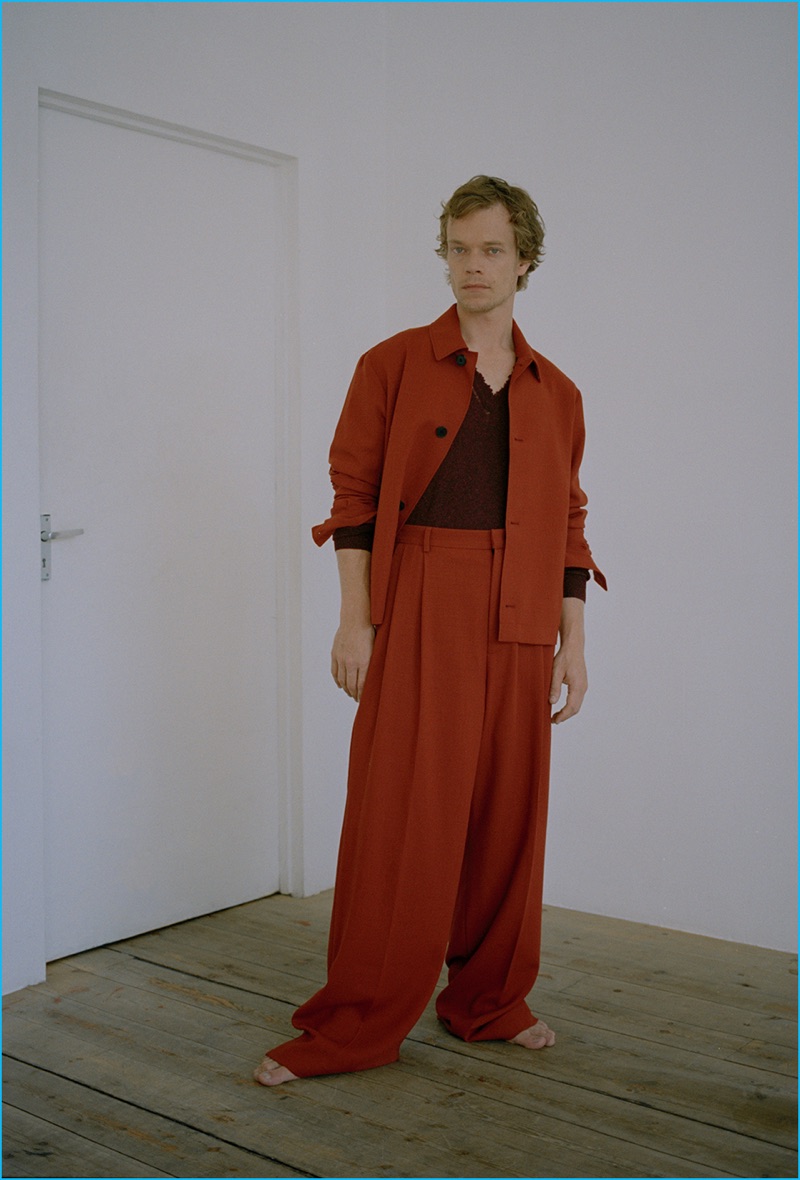 Making a bold statement, Alfie Allen wears an oversized suit by McQ Alexander McQueen. Allen also sports a distressed sweater from Lanvin.