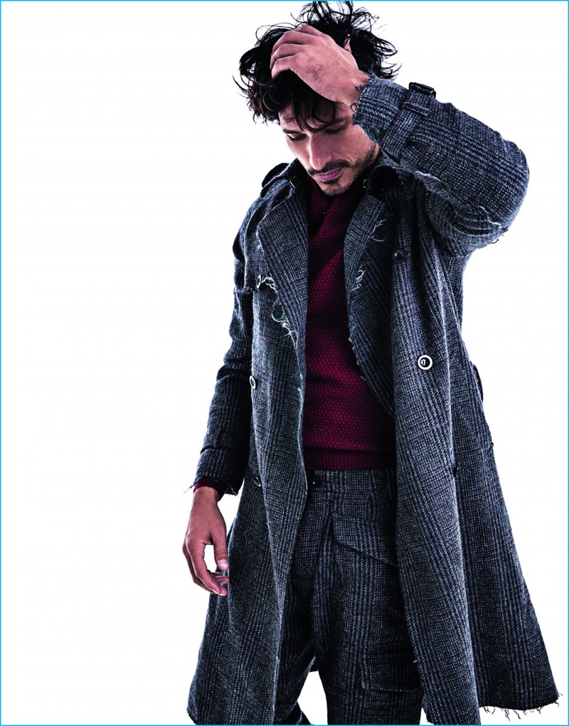 Embracing the distressed trend, Andres Velencoso wears a Loewe coat and trousers with a Massimo Dutti sweater.