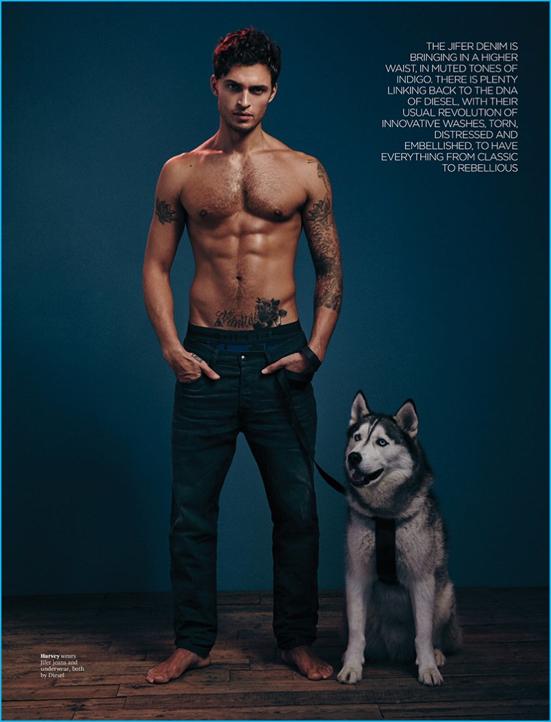 Wearing denim jeans, a shirtless Harvey Haydon poses with his Husky, Xavier.