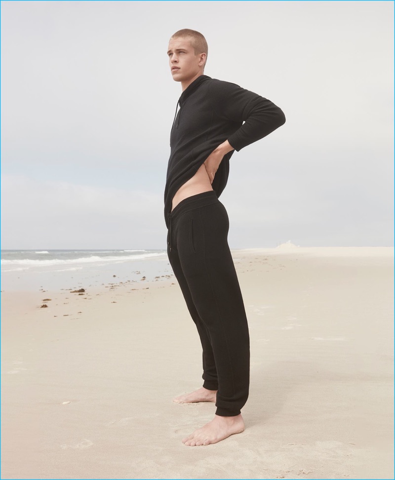 Mitchell Slaggert models a black cowl neck sweatshirt and sweatpants from Calvin Klein Collection's pre-spring 2017 cashmere line.