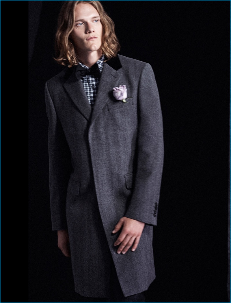 Model Ryan Keating dons a herringbone topcoat, slim check shirt and satin bow-tie from Club Monaco.