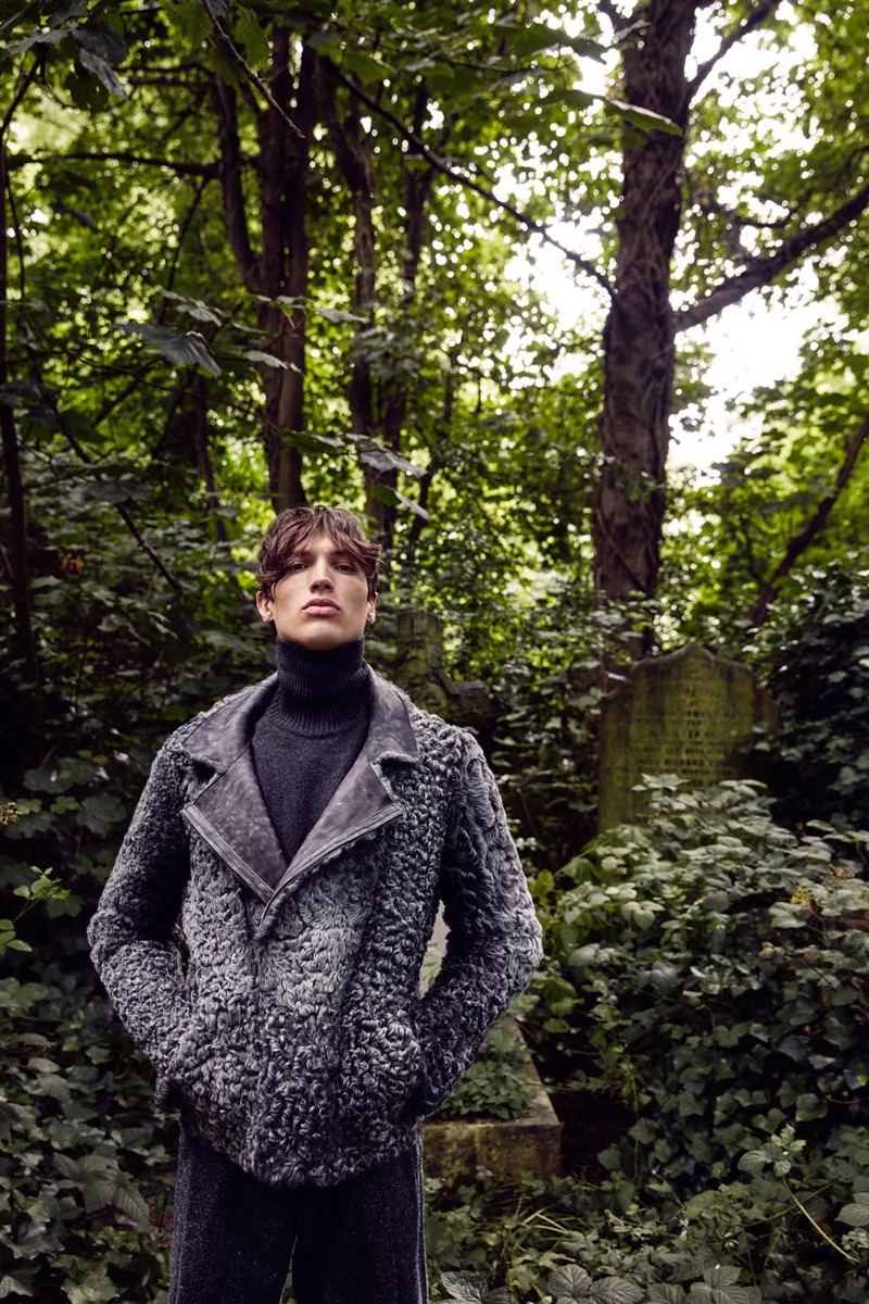 Standing tall, Nick wears a Brora cashmere turtleneck with an Emporio Armani faux fur jacket and grey trousers.