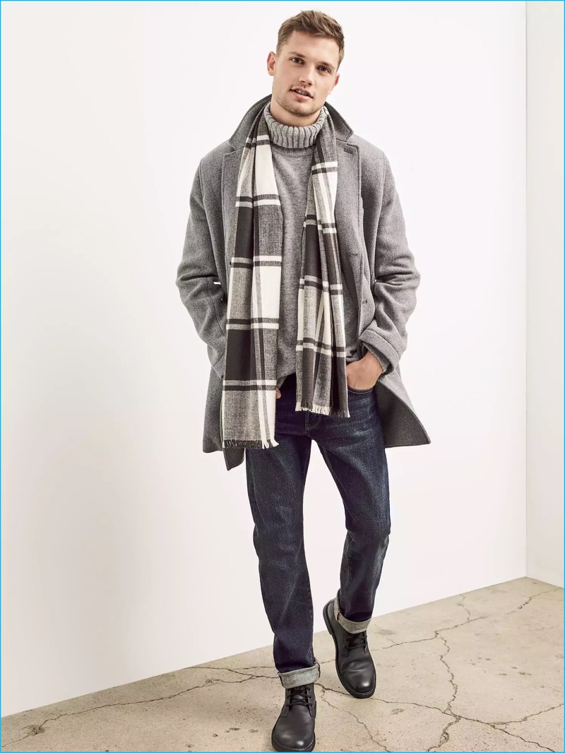 Charming in a grey wool coat, Stefan Pollmann also wears a turtleneck sweater, distressed denim jeans, and black leather boots.