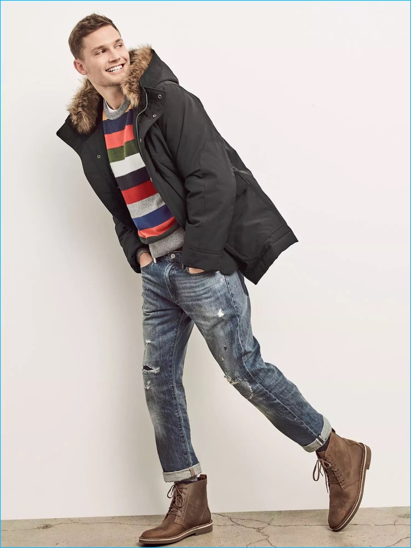 All smiles, Stefan Pollman dons a multi-color striped sweater with a parka, distressed denim jeans, and brown leather boots from Gap.