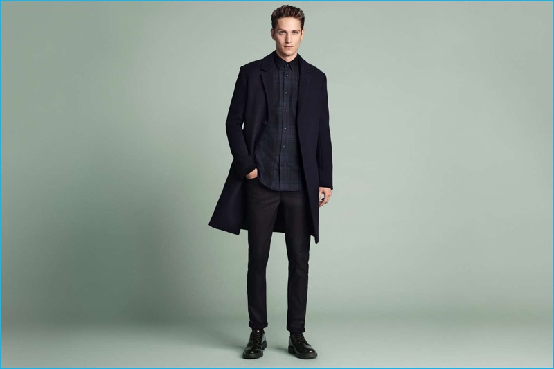 Model Peter Bruder sports a flannel shirt, wool-blend coat, slim coated jeans, and derbies from H&M.