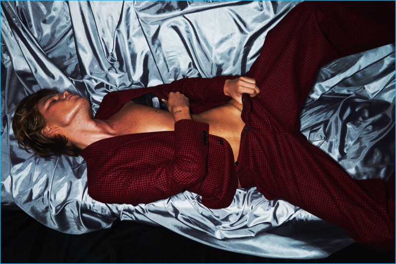 Model Jordan Barrett wears a red and black patterned suit by Dior Homme.