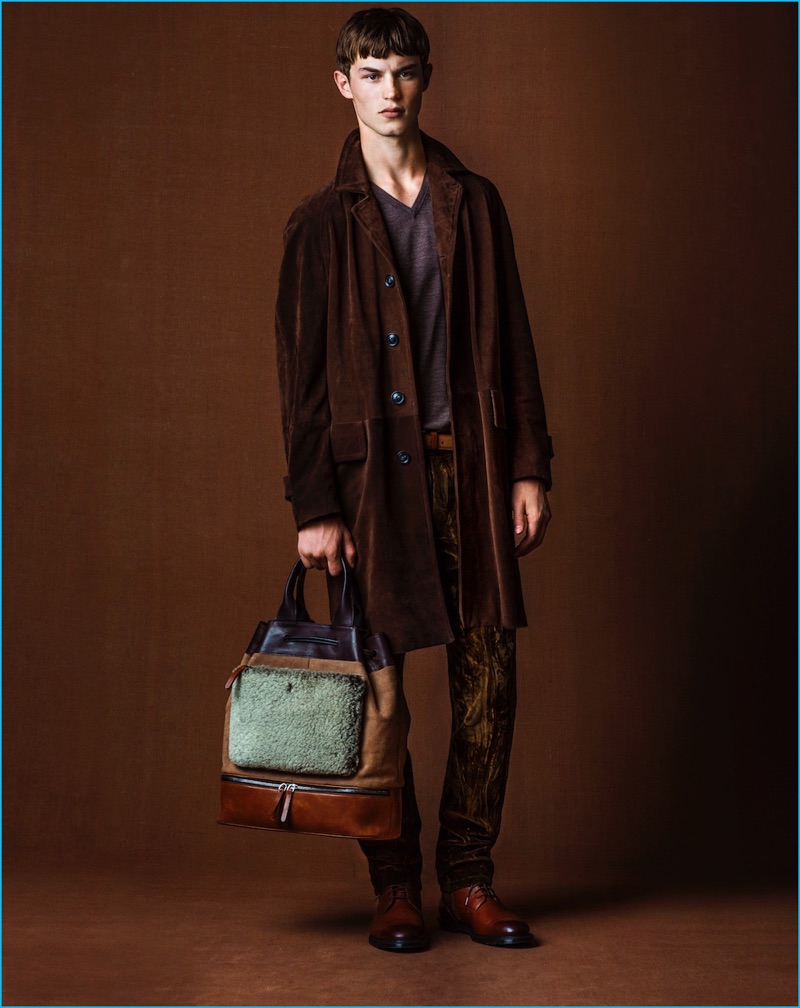 Carrying a Trussardi bag, Kit Butler models a coat from the Italian brand with a UNIQLO sweater and John Varvatos pants.