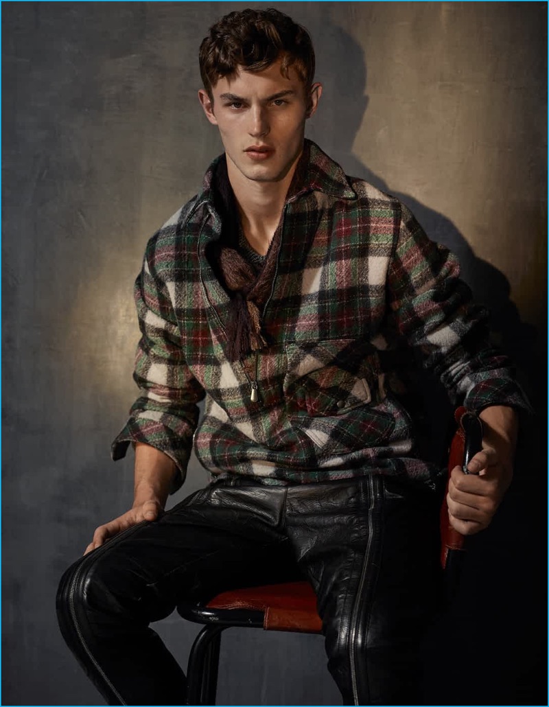 Kit Butler wears a check wool jacket, sweater, leather pants, and wool scarf by Bottega Veneta.