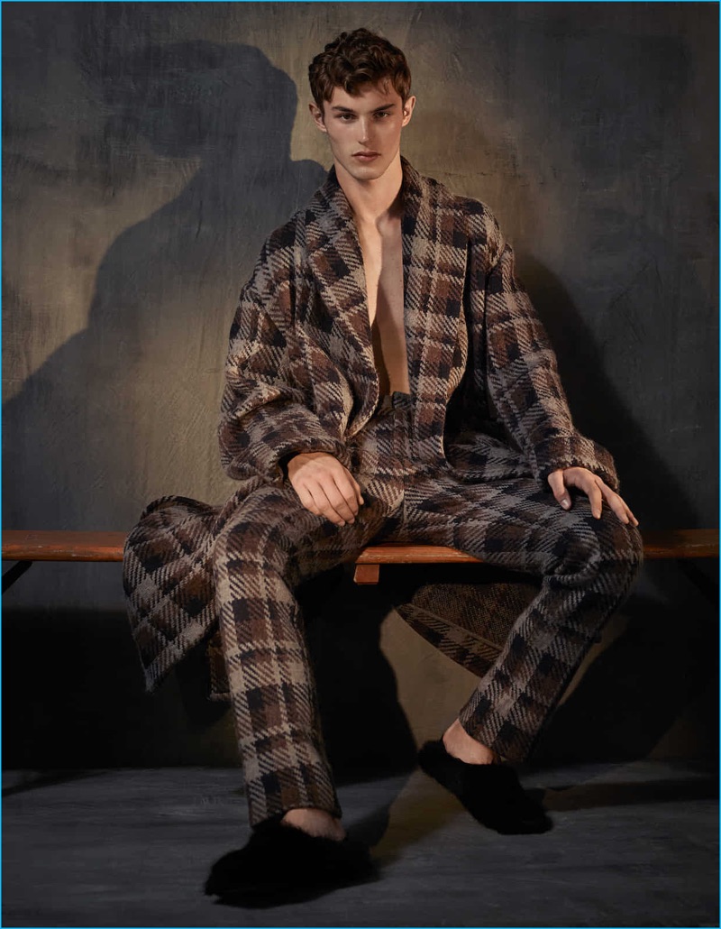 Embracing a pajama-inspired look, Kit Butler wears a check coat and trousers with shearling slippers by Fendi.