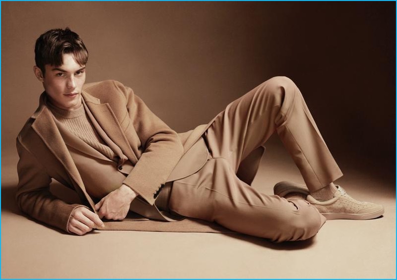 Dressed in camel wool fashions, Kit Butler dons a Joseph sweater, suit and coat with Fred Perry sneakers.