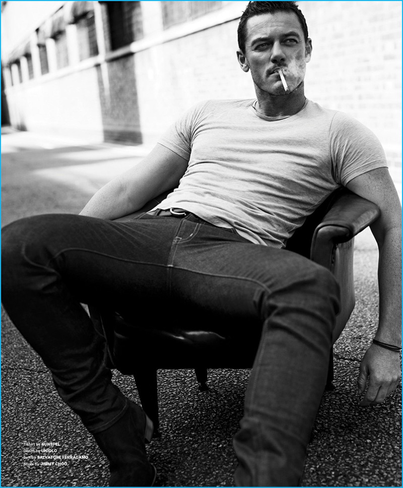 Tom Stubbs outfits Luke Evans in a Sunspel t-shirt and UNIQLO denim jeans with a Salvatore Ferragamo belt and Jimmy Choo boots.