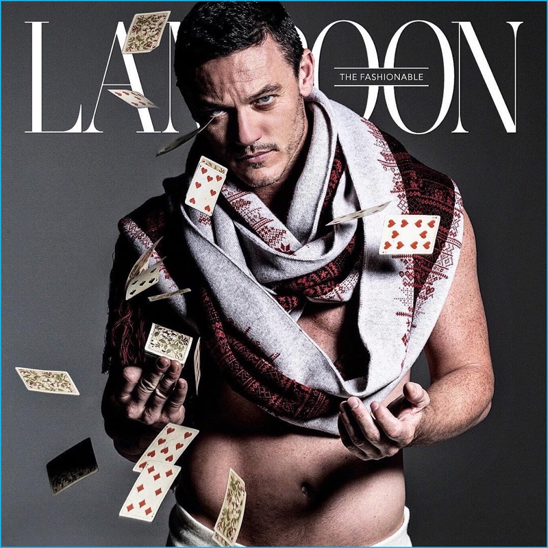 Posing with a deck of cards, Luke Evans covers The Fashionable Lampoon.