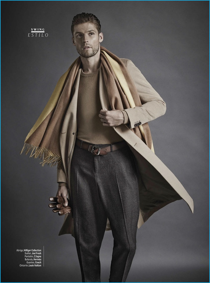 Model Mikus Lasmanis wears a camel coat by Tommy Hilfiger with a Joe Fresh sweater. Mikus also sports Z Zegna trousers with a Hermes scarf, a Louis Vuitton belt, and Coach leather gloves.