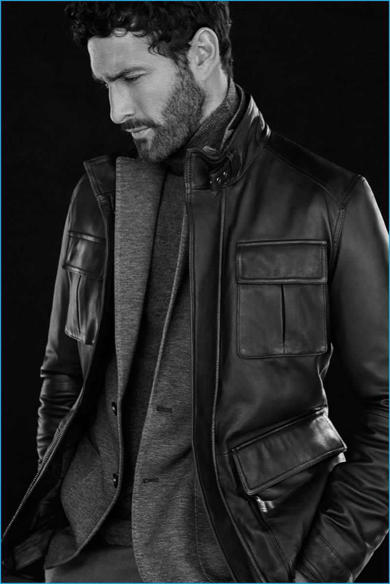 Appearing in an editorial for Massimo Dutti, Noah Mills wears a leather field jacket with a sport coat and turtleneck sweater.