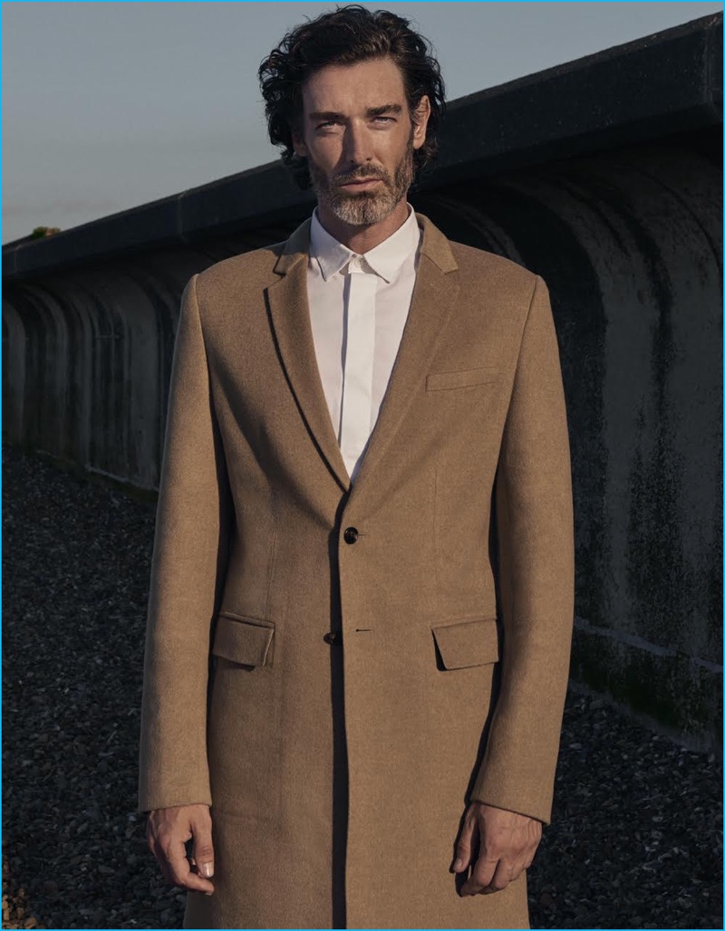 Richard Biedul dons a single-breasted camel coat and white dress shirt from Dior Homme.