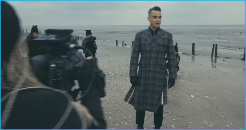 Robbie Williams dons a double-breasted plaid coat by Thom Browne for his Love My Life music video.