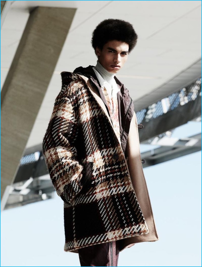Channeling a retro attitude, Sol Goss wears plaid duffle coat from CMMN SWDN. Sol also sports a Prada shirt, Oscar Jacobson turtleneck and SAND Copenhagen pants.