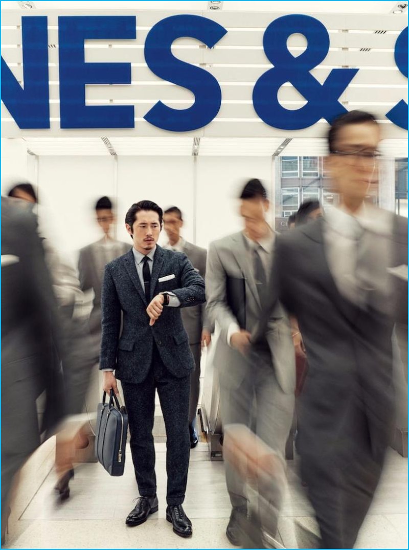 Caught in rush hour, Steven Yeun sports a J.Crew Ludlow suit, Z Zegna shirt, an Alexander Olch tie, To Boot New York dress shoes, a Brooks Brothers pocket square, Montblanc watch, and Louis Vuitton briefcase.