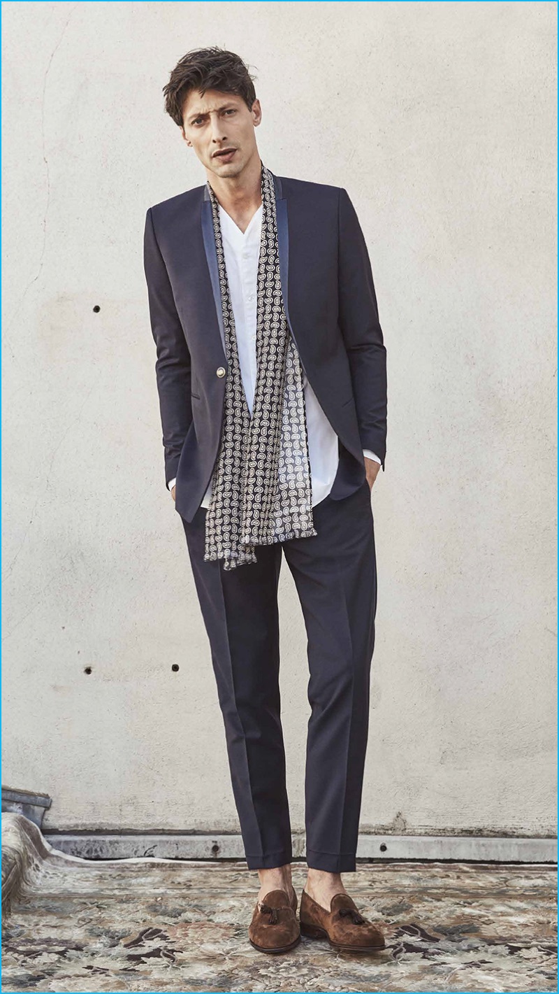 Appearing in The Kooples' spring-summer 2017 men's lookbook, Jonas Mason wears a one-button suit with a collarless shirt and scarf.