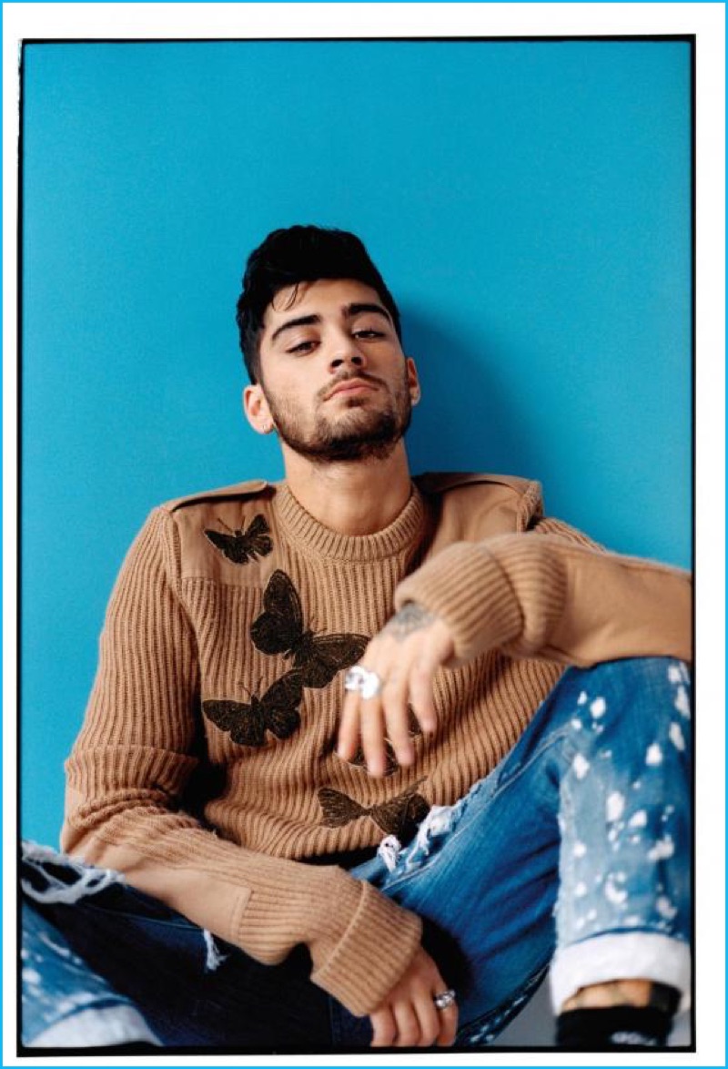 Singer Zayn Malik wears an Alexander McQueen butterfly sweater with distressed Dsquared2 jeans.