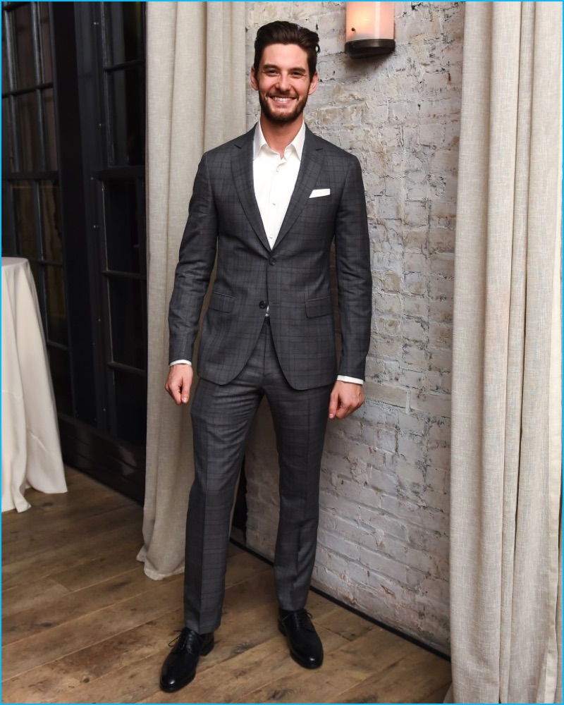 Ben Barnes is all smiles in a charcoal two-button Salvatore Ferragamo suit.