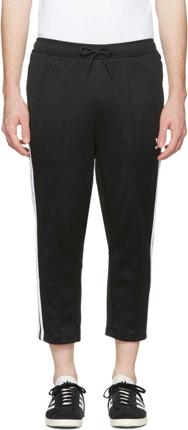 Slim-fit jersey lounge pants in black. Cropped fit. Drawstring at elasticized waistband. Four-pocket styling. Logo graphic printed in white at front. Raised seams at front and back. Signature stripes in white at outseams. Tonal stitching. 30% cotton, 70% polyester.