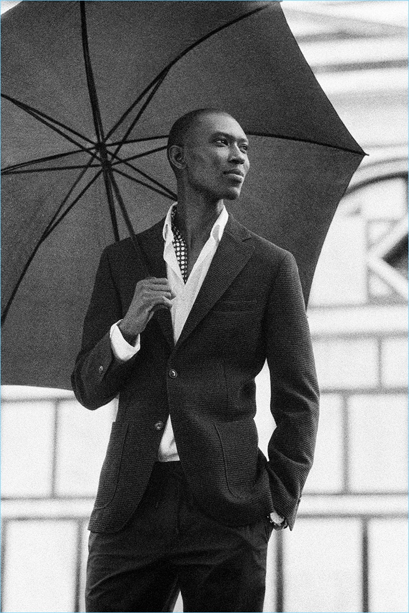 A sleek vision, Armando Cabral dons a wool and cotton blend blazer with a stretch shirt, printed linen scarf, and jogging-style trousers from Massimo Dutti.