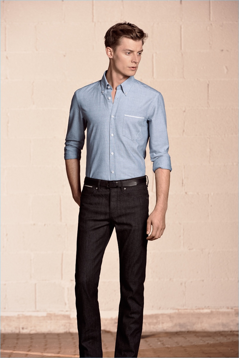 Cutting a lean shape, Janis Ancens wears a fitted shirt with dark wash denim jeans from BOSS Hugo Boss.