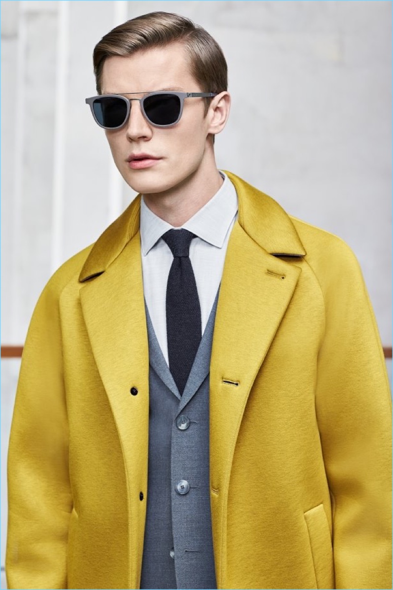 Janis Ancens dons a yellow statement coat with a grey three-button suit by BOSS Hugo Boss.