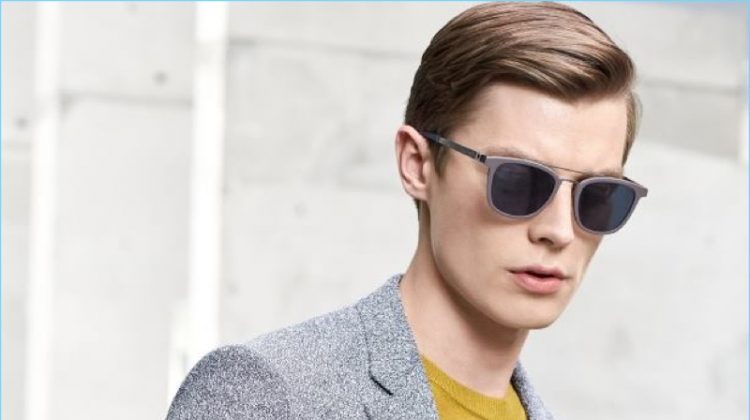 Donning grey shades, Janis Ancens is a sleek vision in a BOSS sportcoat and yellow sweater. The Latvian model also carries a leather portfolio.