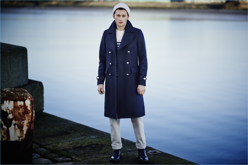 Model Bastian Thiery channels naval style in a navy double-breasted coat by Belstaff.