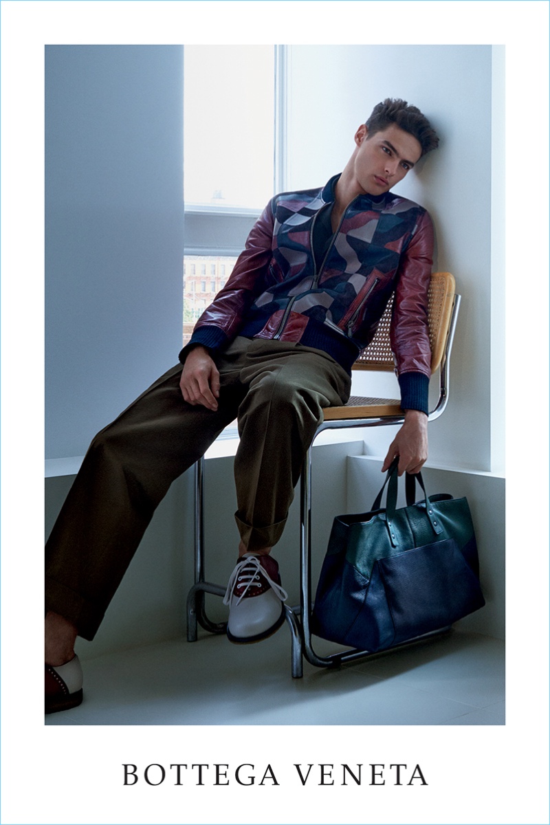 Hannes Gobeyn sports a multi-color leather bomber jacket with pleated trousers for Bottega Veneta's spring-summer 2017 campaign.