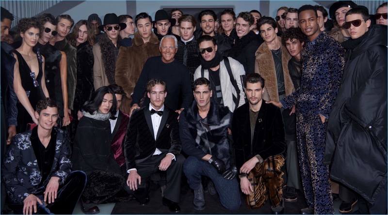 Designer Giorgio Armani poses for pictures with models who walked Emporio Armani's fall-winter 2017 men's show.