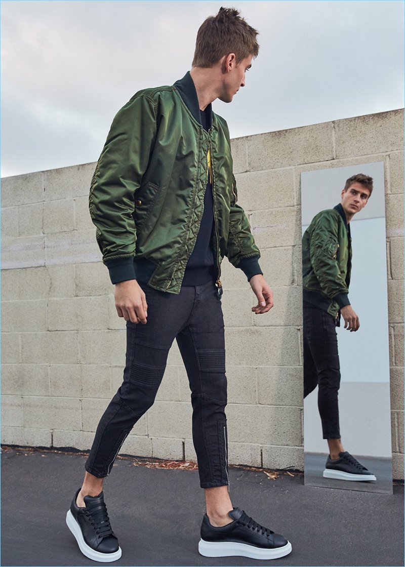 Tapping into the military trend, Samuel Roberts sports a Burberry bomber jacket with a Loewe elephant sweater, Neil Barrett biker jeans, and Alexander McQueen leather platform sneakers.