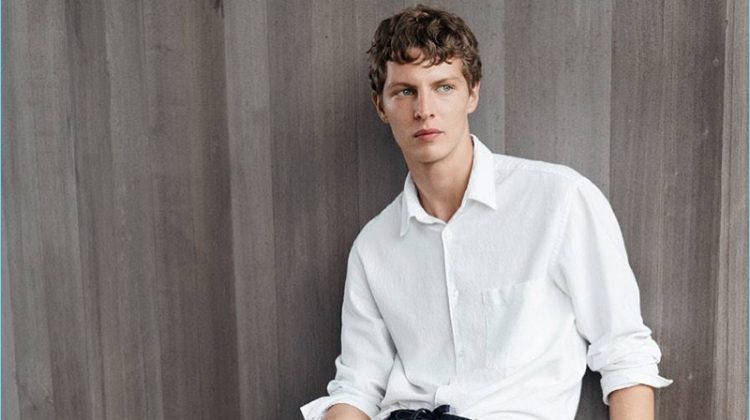 Model Tim Schuhmacher relaxes in H&M's linen-blend shirt, joggers, and white sneakers.