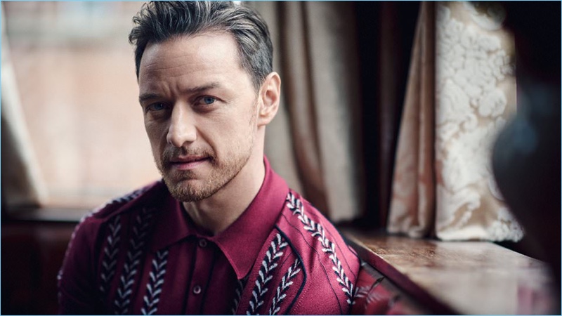 Showing a head full of grey, James McAvoy wears a burgundy knit polo by Prada.