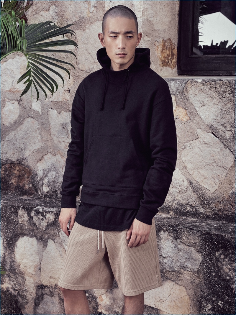 Korean model Sung Jin Park sports a black hoodie with khaki shorts by John Elliott.