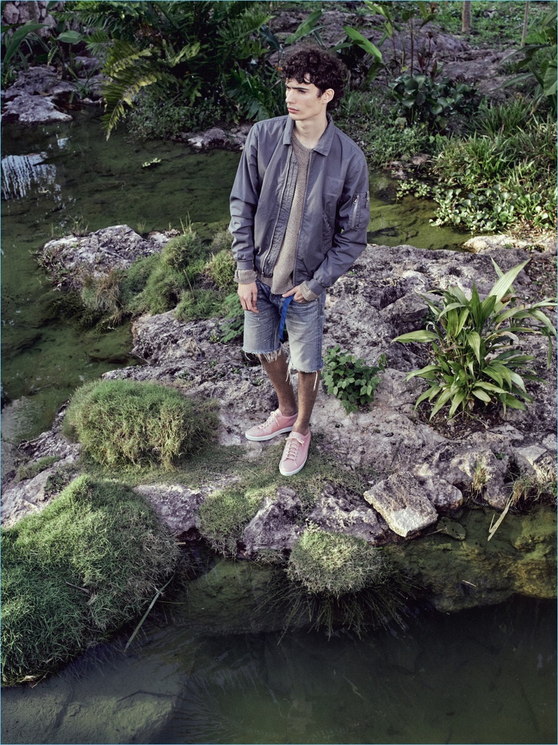 Venturing outdoors, Piero Mendez wears a bomber jacket with frayed denim shorts from John Elliott.