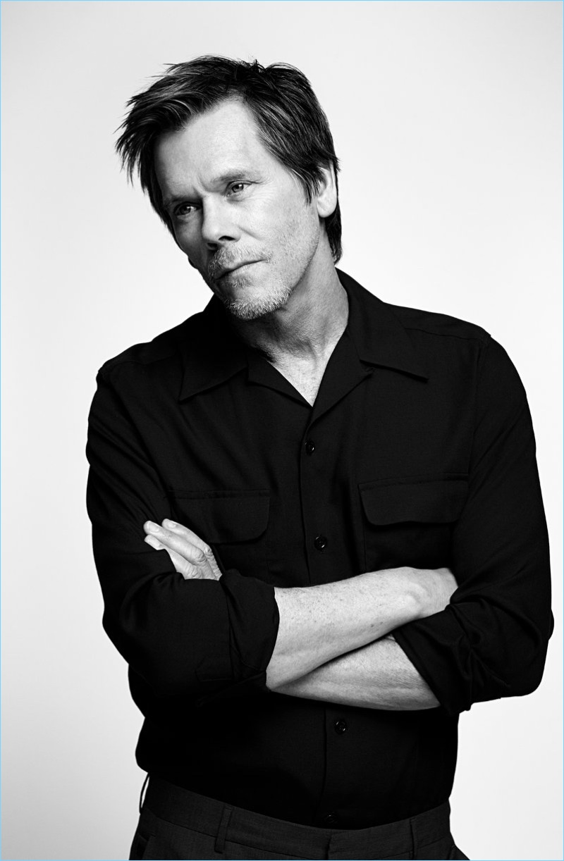 Dressed in black, Kevin Bacon sports a Wacko Maria camp collar shirt with Prada virgin wool trousers.