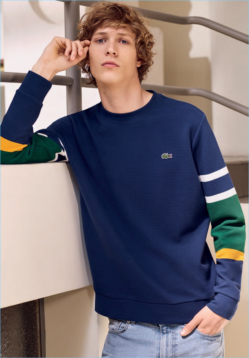 Model Sven de Vries sports a color blocked pullover by Lacoste.