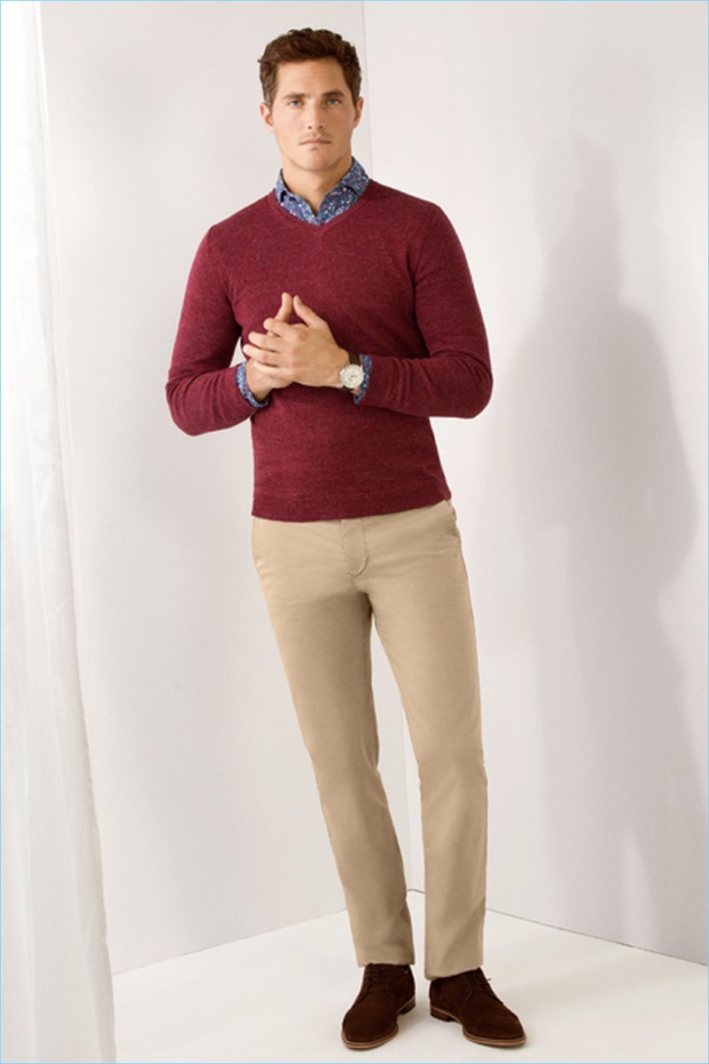 Making a red statement, Ollie Edwards dons a v-neck sweater with chinos by Pedro del Hierro.