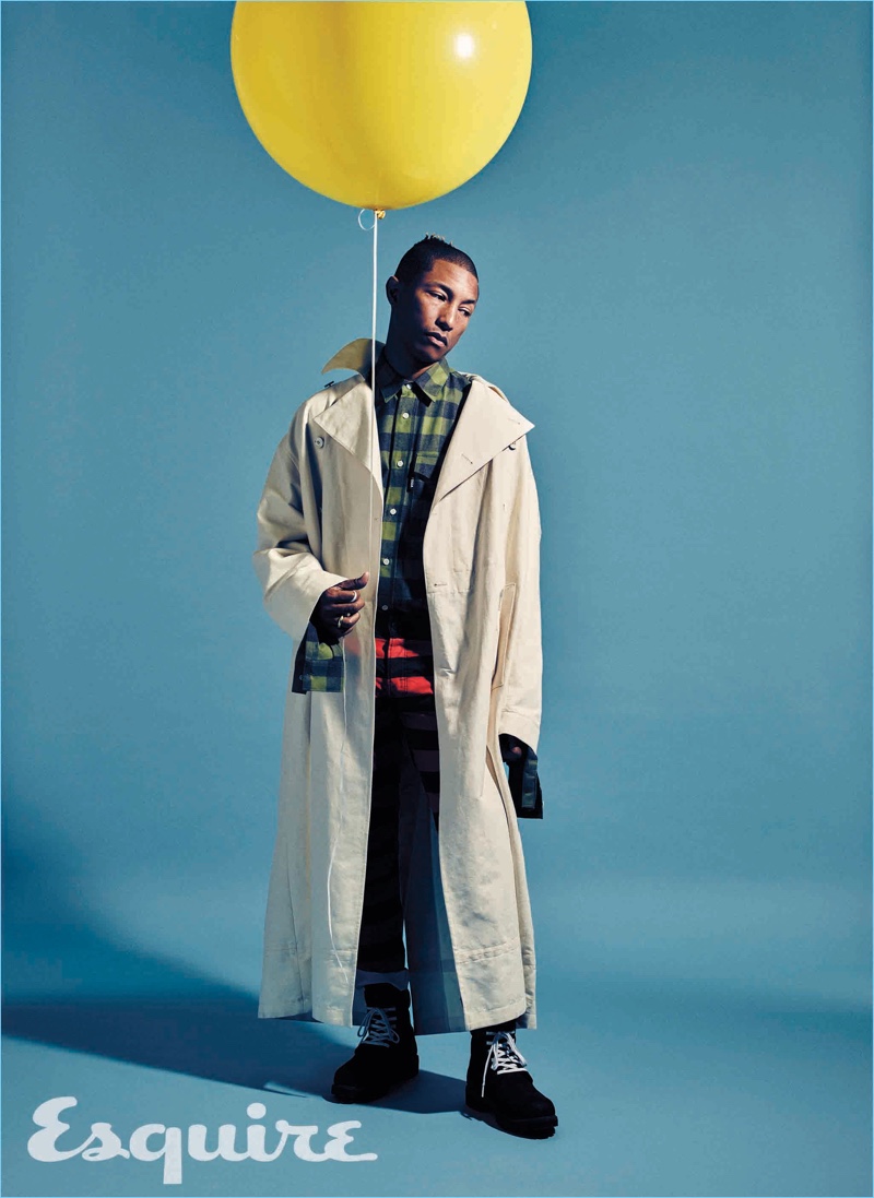 Posing for a quirky image with balloon in hand, Pharrell dons an oversized Dries Van Noten coat. Pharrell also wears a Gosha Rubchinskiy check shirt, G-Star trousers, and Timberland boots.