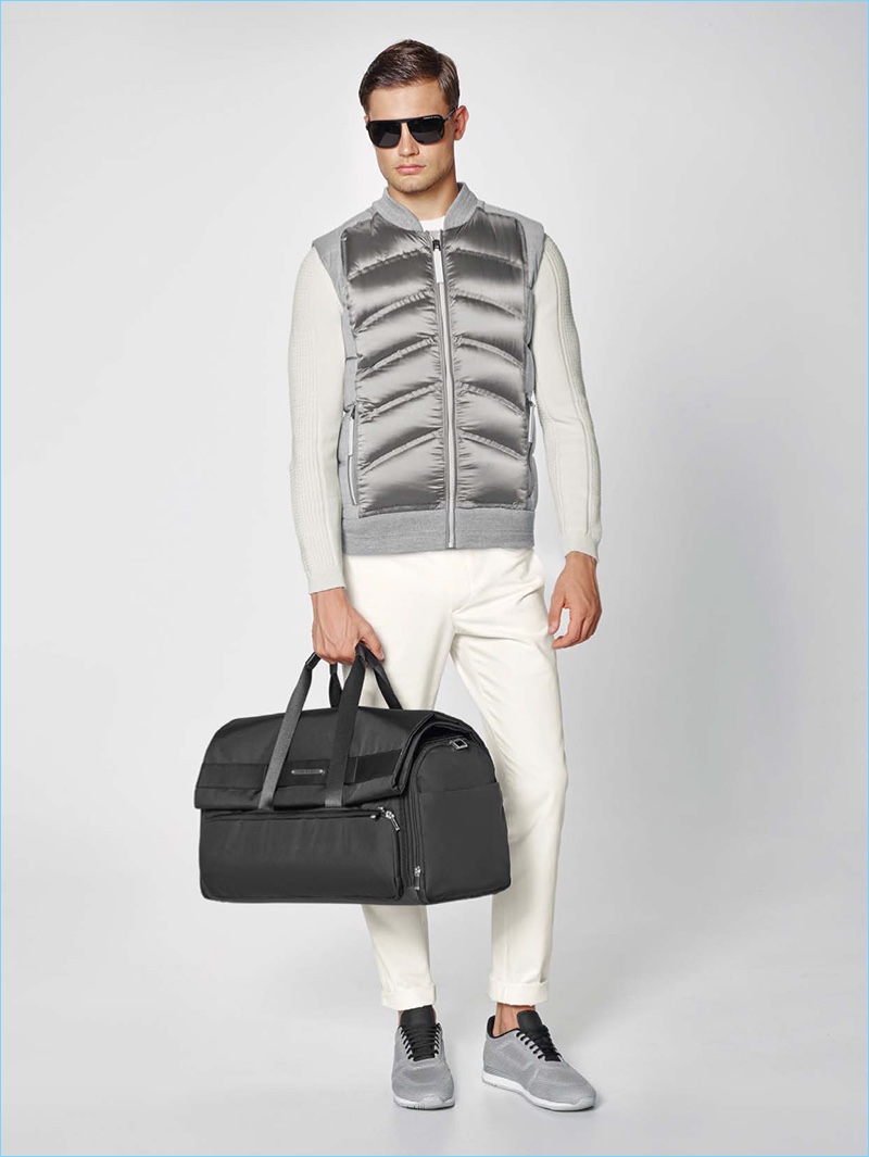 Sporty style reigns as Porsche Design turns out a quilted vest with cotton blend pants, a knit sweater, and grey sneakers.