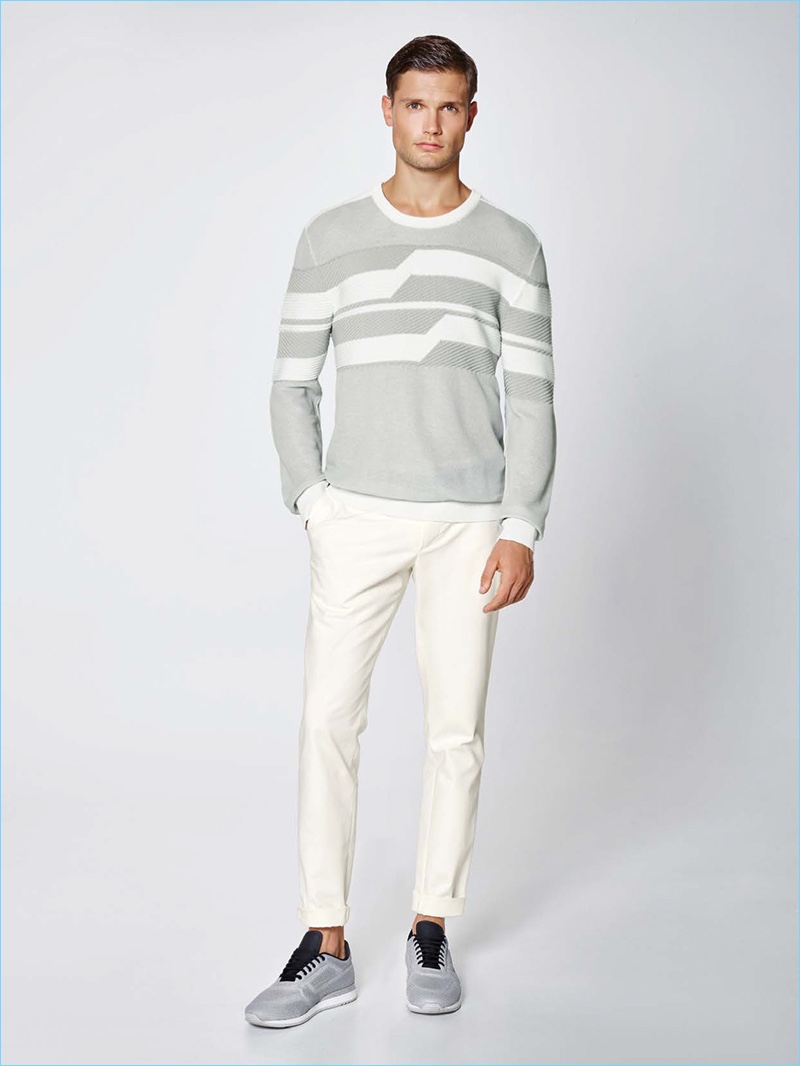 Stefan Pollmann goes monochromatic in a graphic sweater, cotton-blend pants, and grey sneakers by Porsche Design.