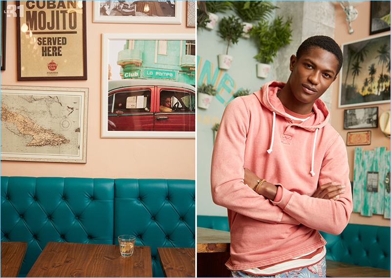 A relaxed vision, Hamid Onifade wears a pale pastel hoodie, striped t-shirt, and floral Bermudas from LE 31.