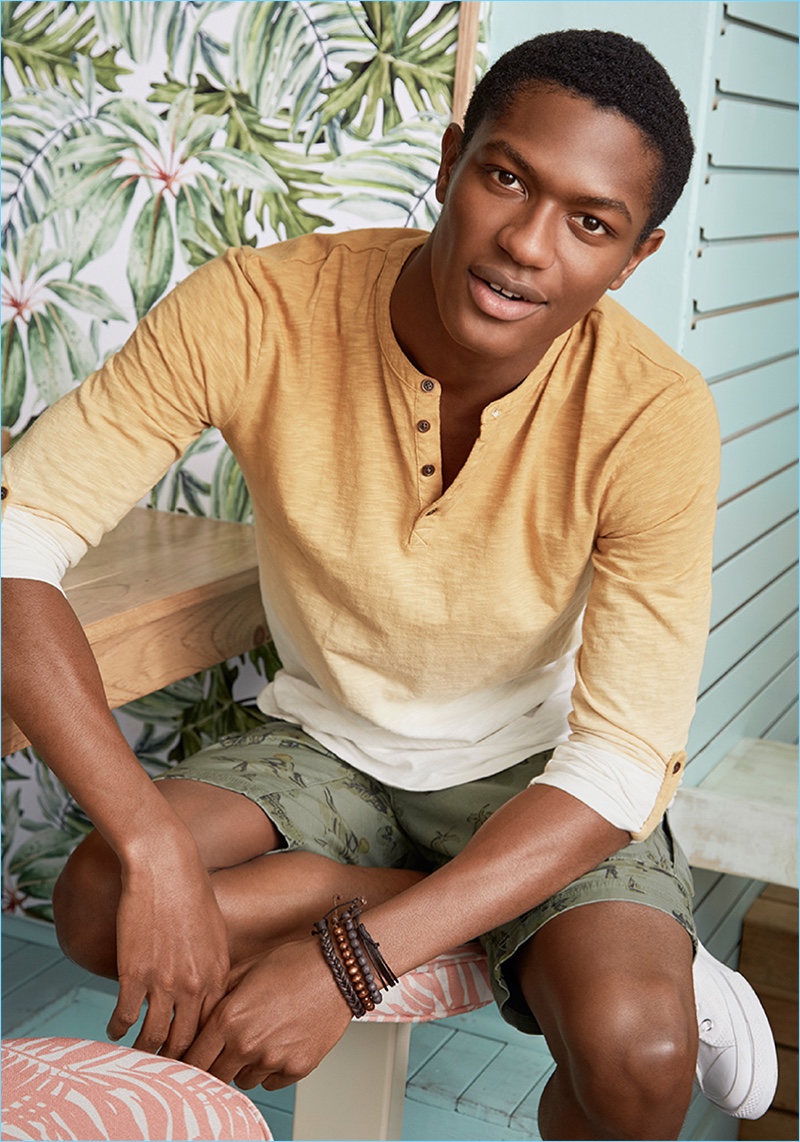 Tapping into the ombré trend, Hamid Onifade wears a gradient colored henley with cargo shorts by LE 31.